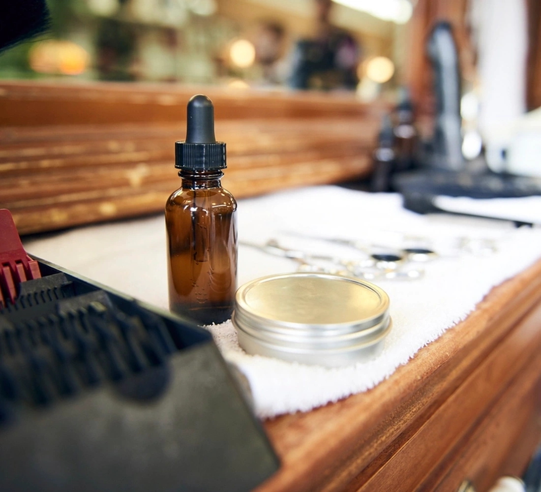 Botol minyak rambut dan pomade di meja barber - foto ilustrasi
